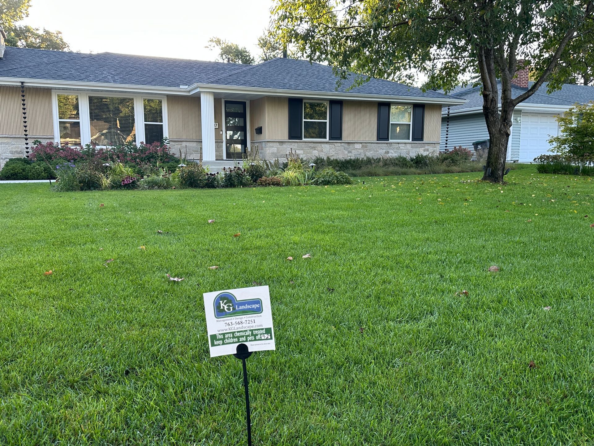 Ranch-style house with manicured lawn and for-sale sign. Dark roof, light siding, and landscaping.