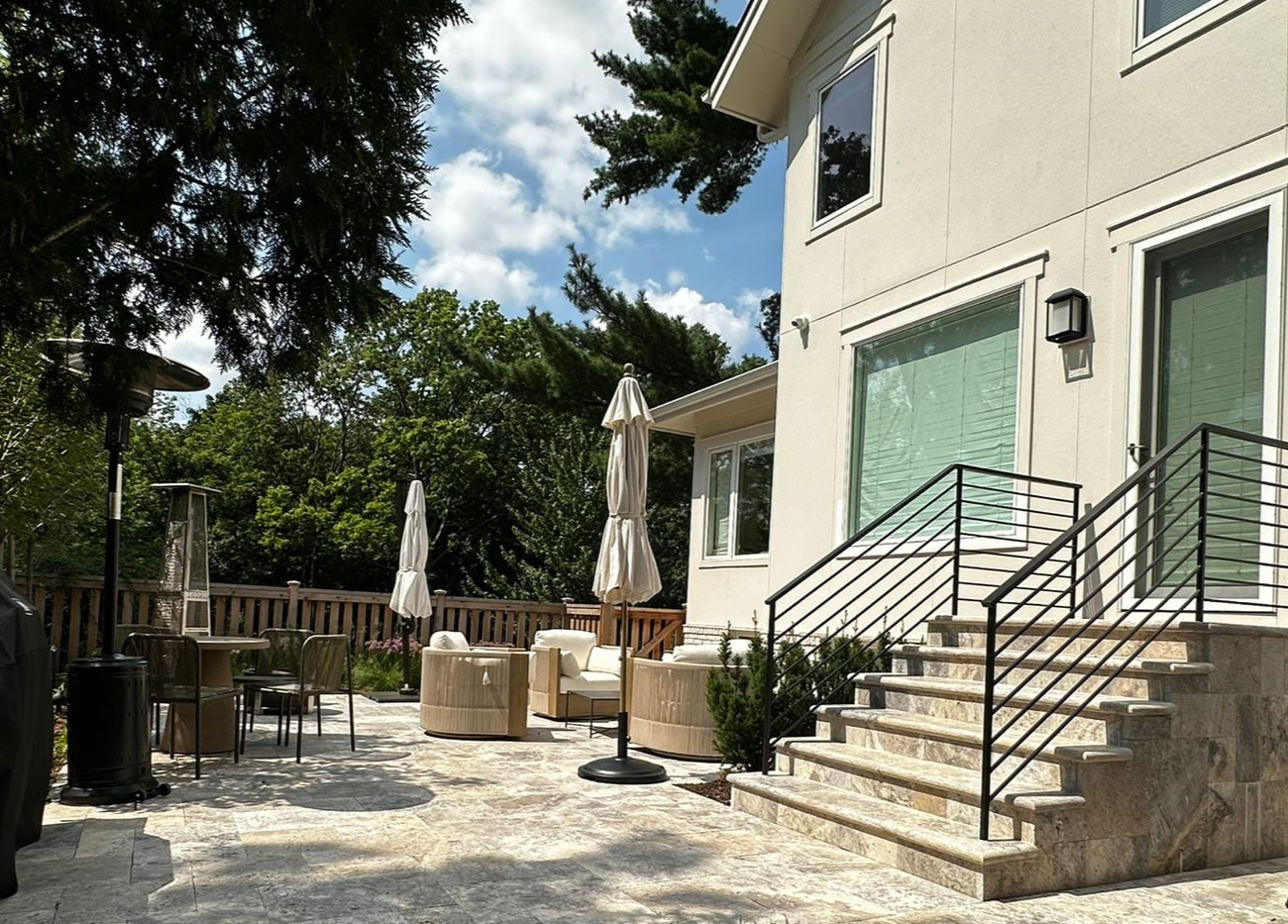 Travertine-faced patio steps and landing with a custom modern handrail in Minneapolis MN