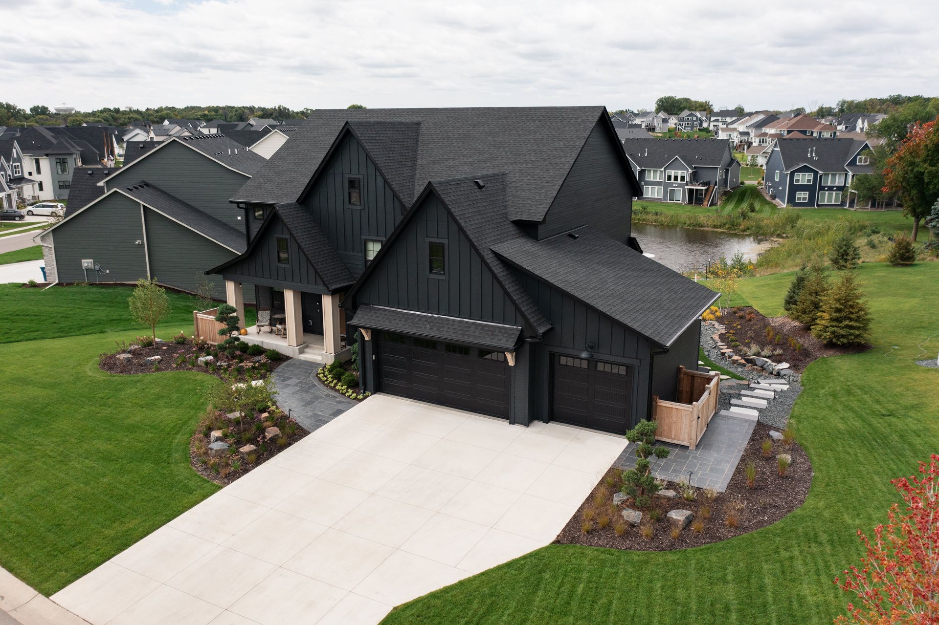 Aerial view of a Plymouth MN front yard with black flagstone walkway, mounded beds, trap boulders, and flowers
