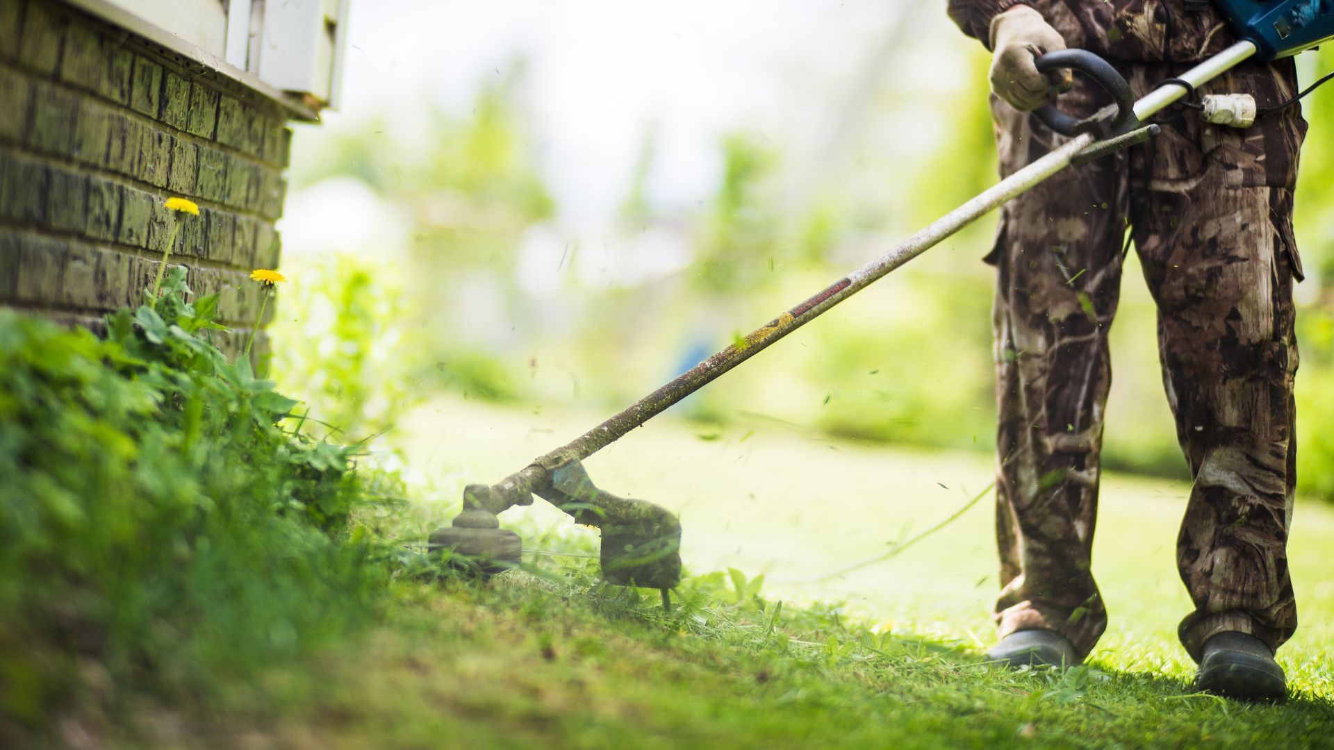 A man is using a lawn mower to cut the grass.