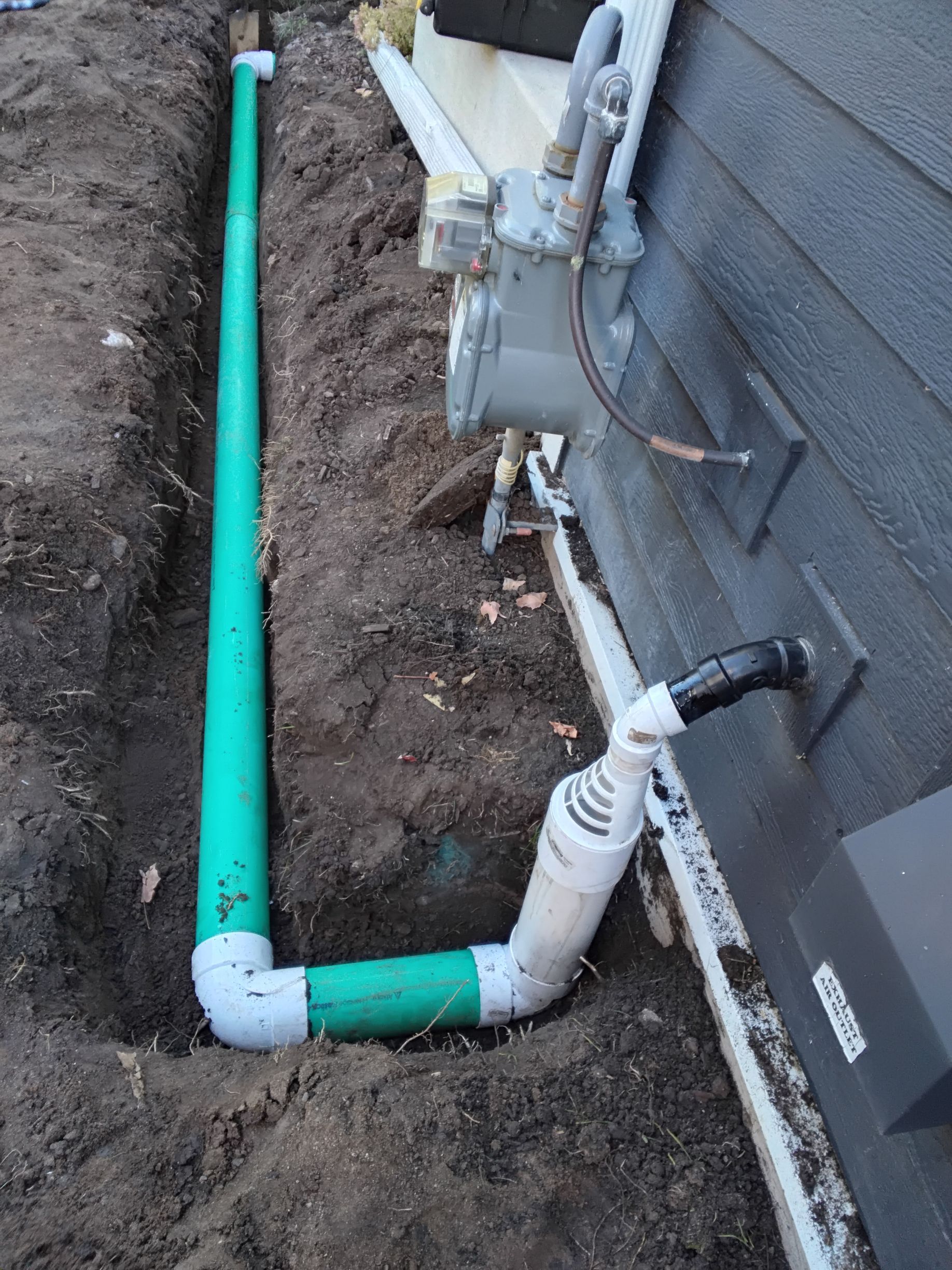 New exterior sump pump discharge connected with air gap running into underground PVC drain pipe in Minneapolis