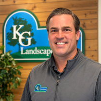 A man wearing a north face vest is smiling for the camera.