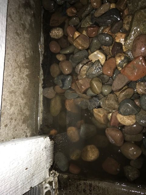 (Before) Water from an active sump pump pooling right up against the foundation, causing basement moisture problems in Edina 