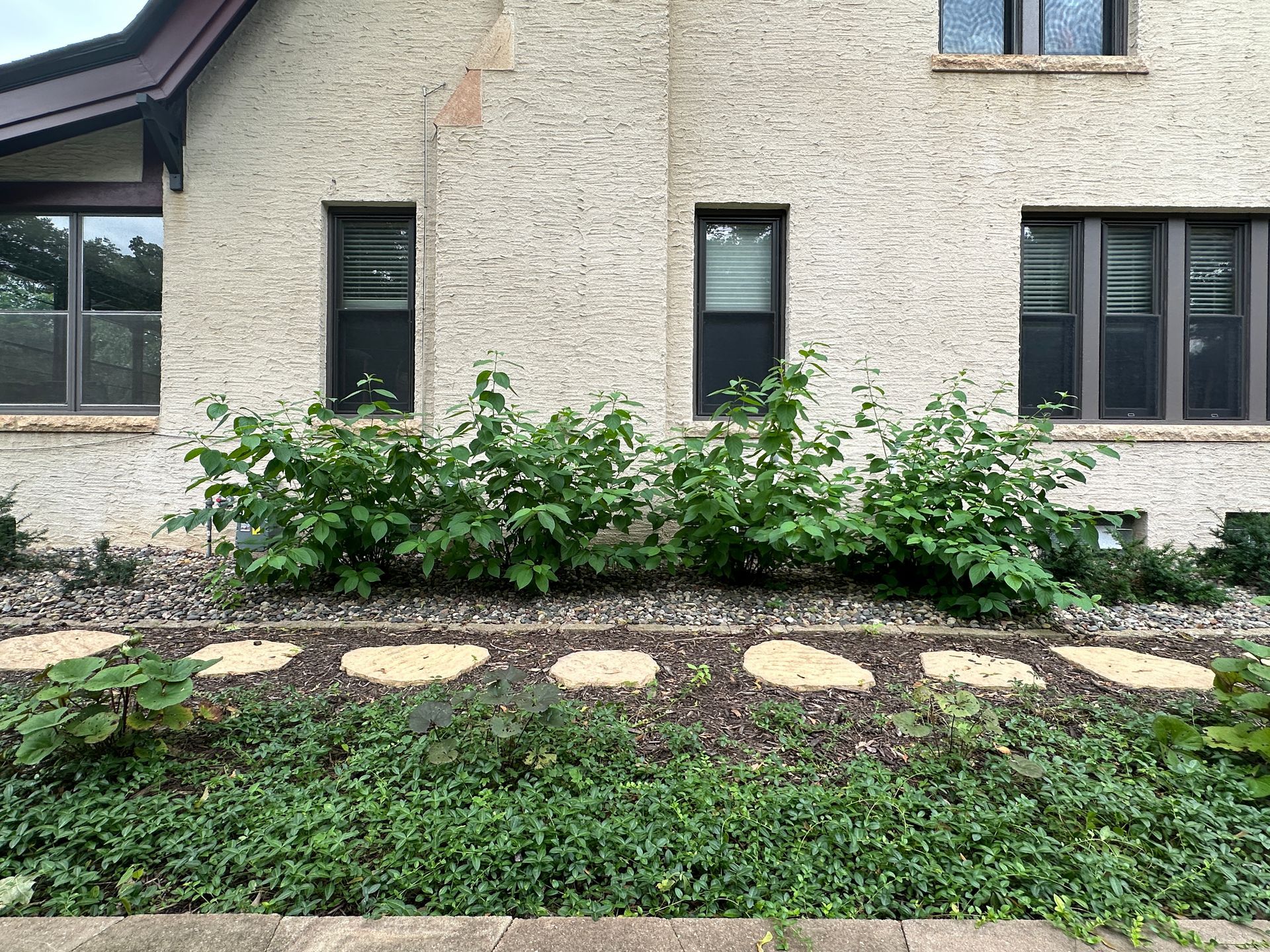 Side yard landscaping with walking path and stepping stones replacing steep hill in Minneapolis by KG Landscape