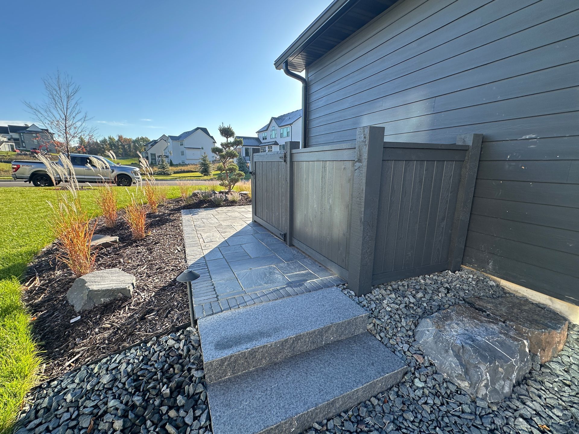 New stone trash bin area in side yard with luxury feel leading to side yard steps project by KG Landscape 
