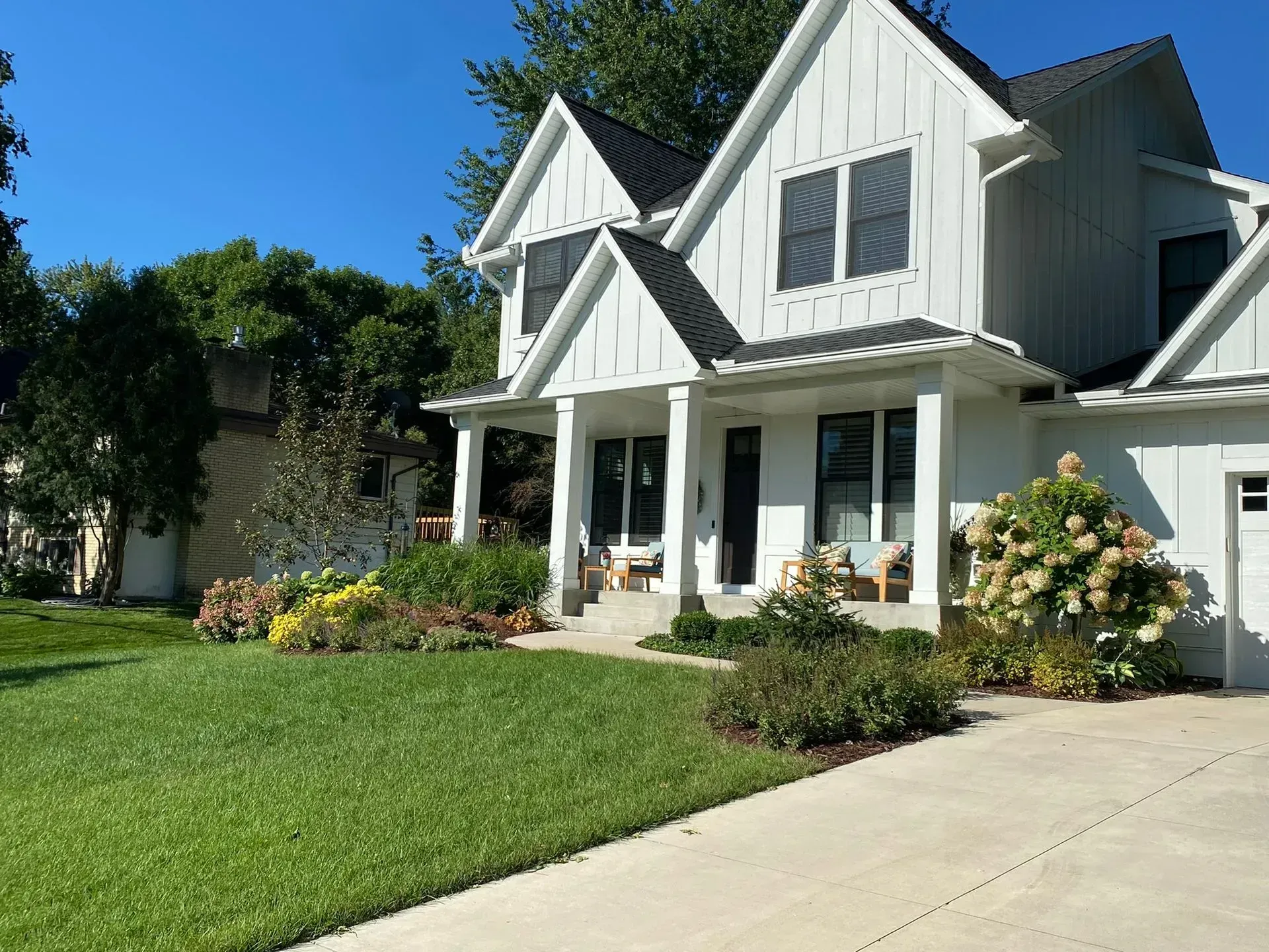 front yard featuring landscaping of white house