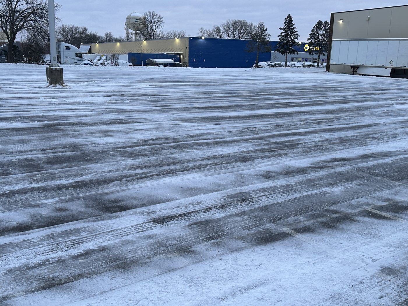 Wide industrial parking lot after plowing, open from end to end