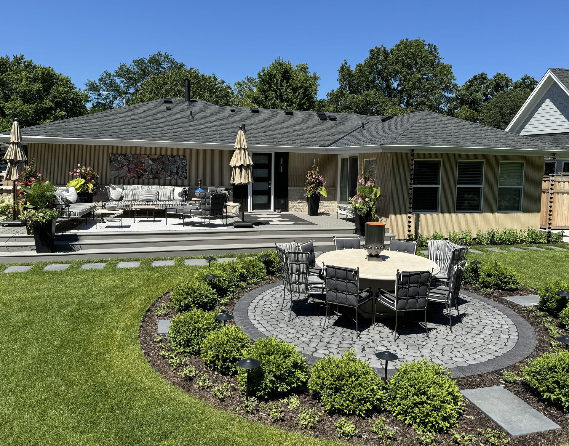 Deck landing and steps down to a dining patio surrounded by flowers in Edina MN