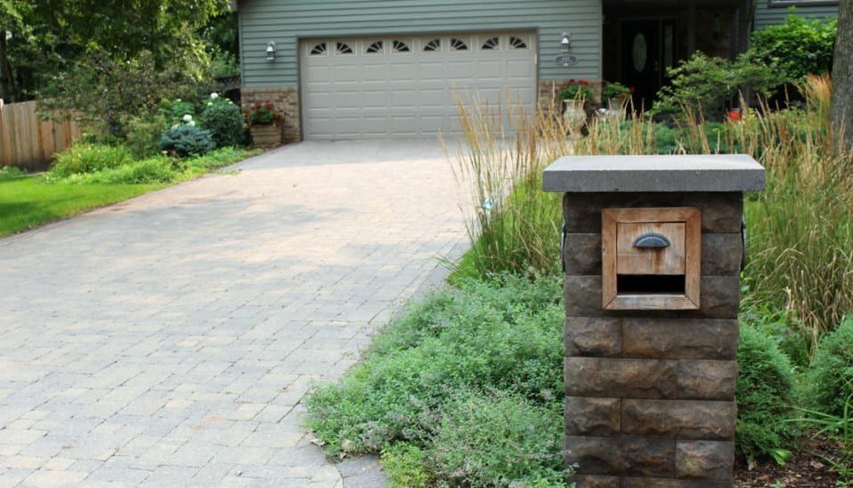 A house with a driveway and a mailbox in front of it