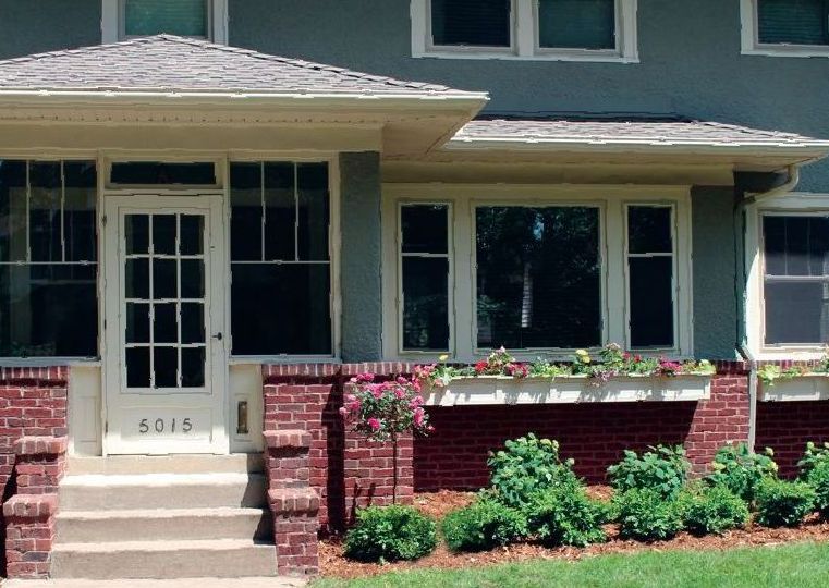 Front porch and red brick planter with new plantings at a 1902 Minneapolis home near 50th and Lyndale