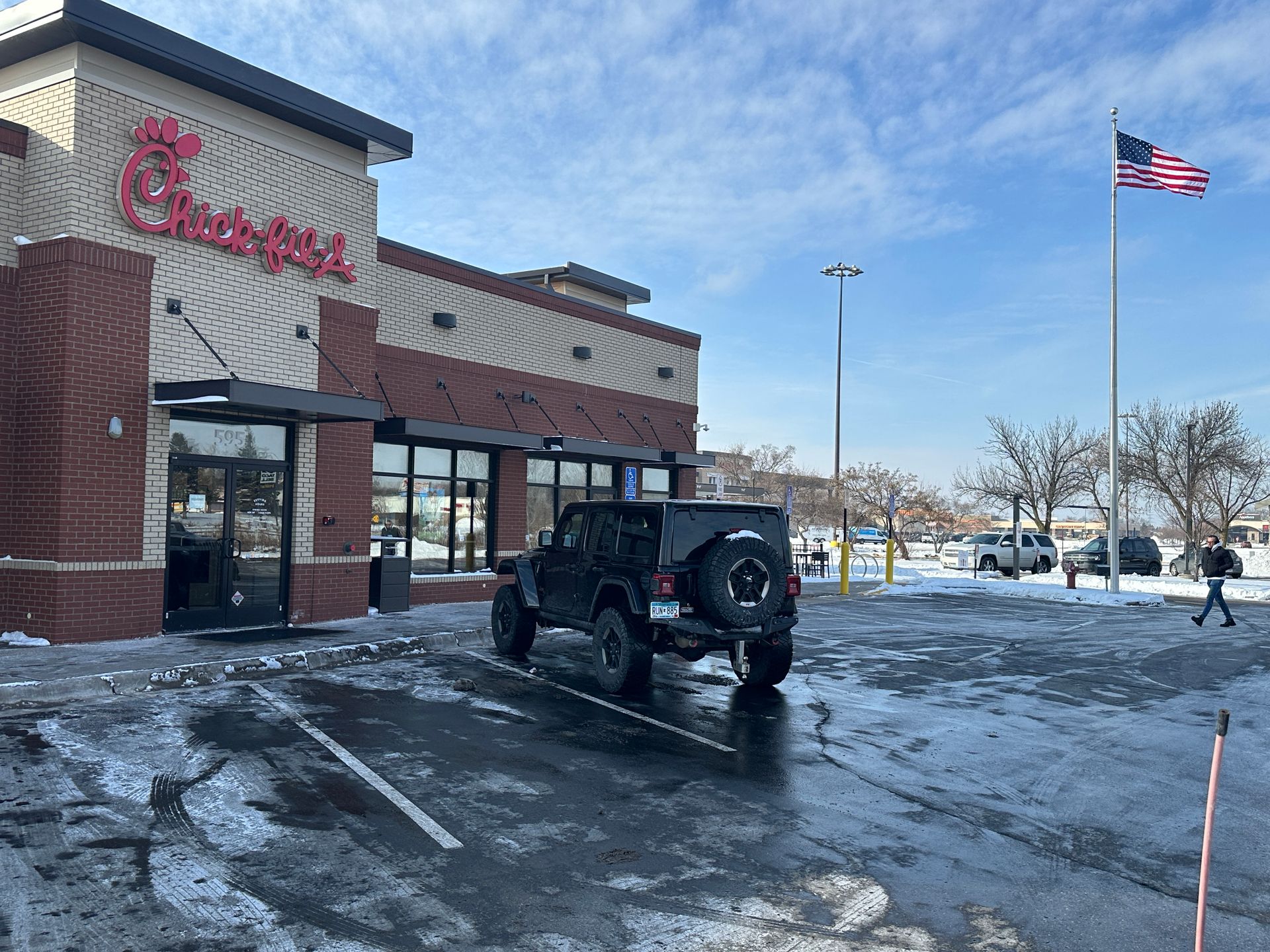 Fast food restaurant parking lot plowed and salted to pavement in Minnesota
