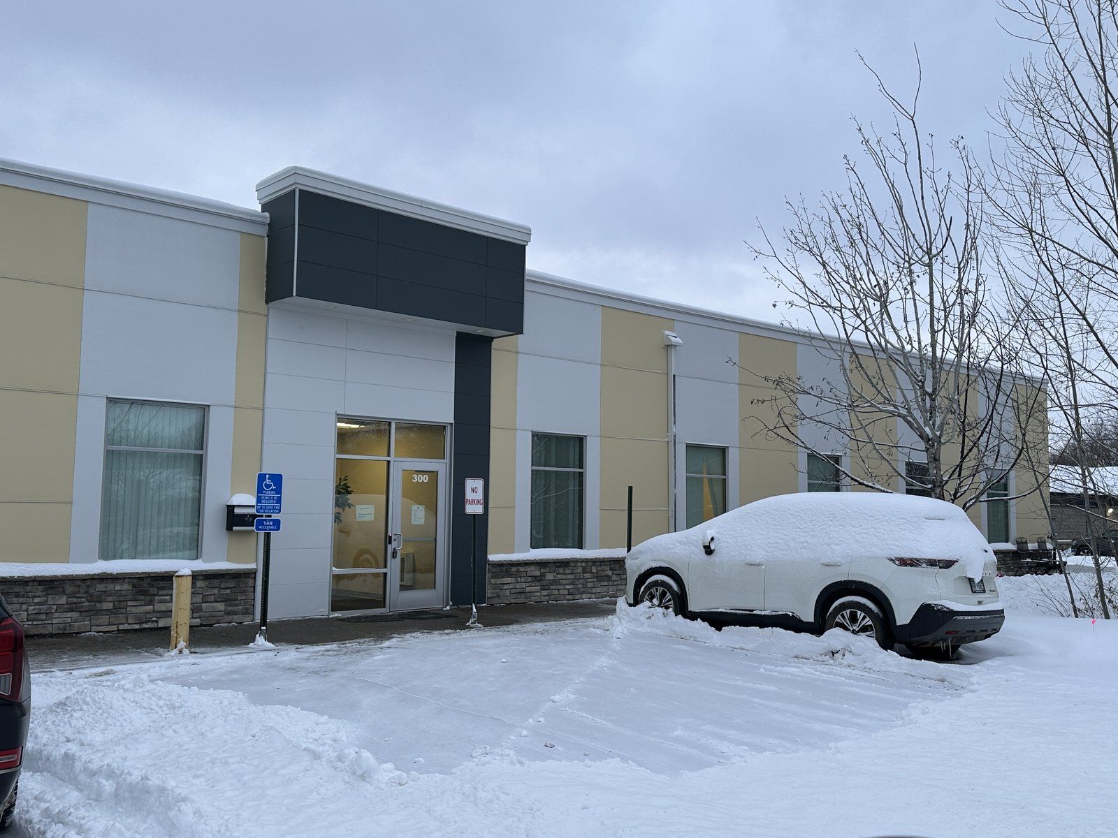 Row of suite entrances at a flex office building with the lot plowed in front