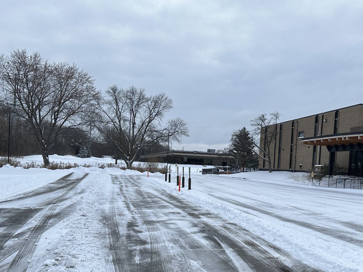 Plowed parking lot with a brick building at the far end