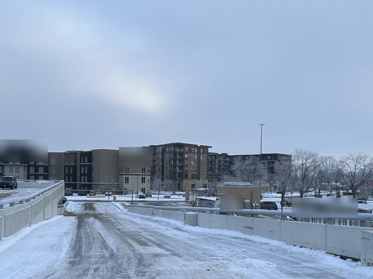 Plowed drive lane with apartment buildings in the distance