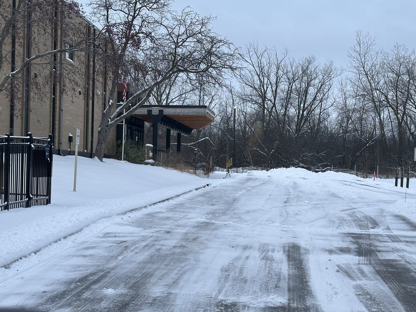 Cleared drive lane beside a brick building after snow