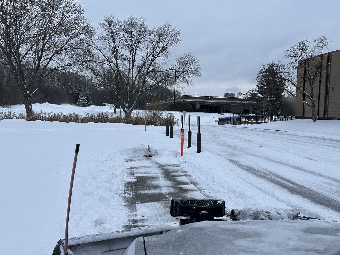 Lot after plowing with marker posts along the edge, viewed from a plow truck