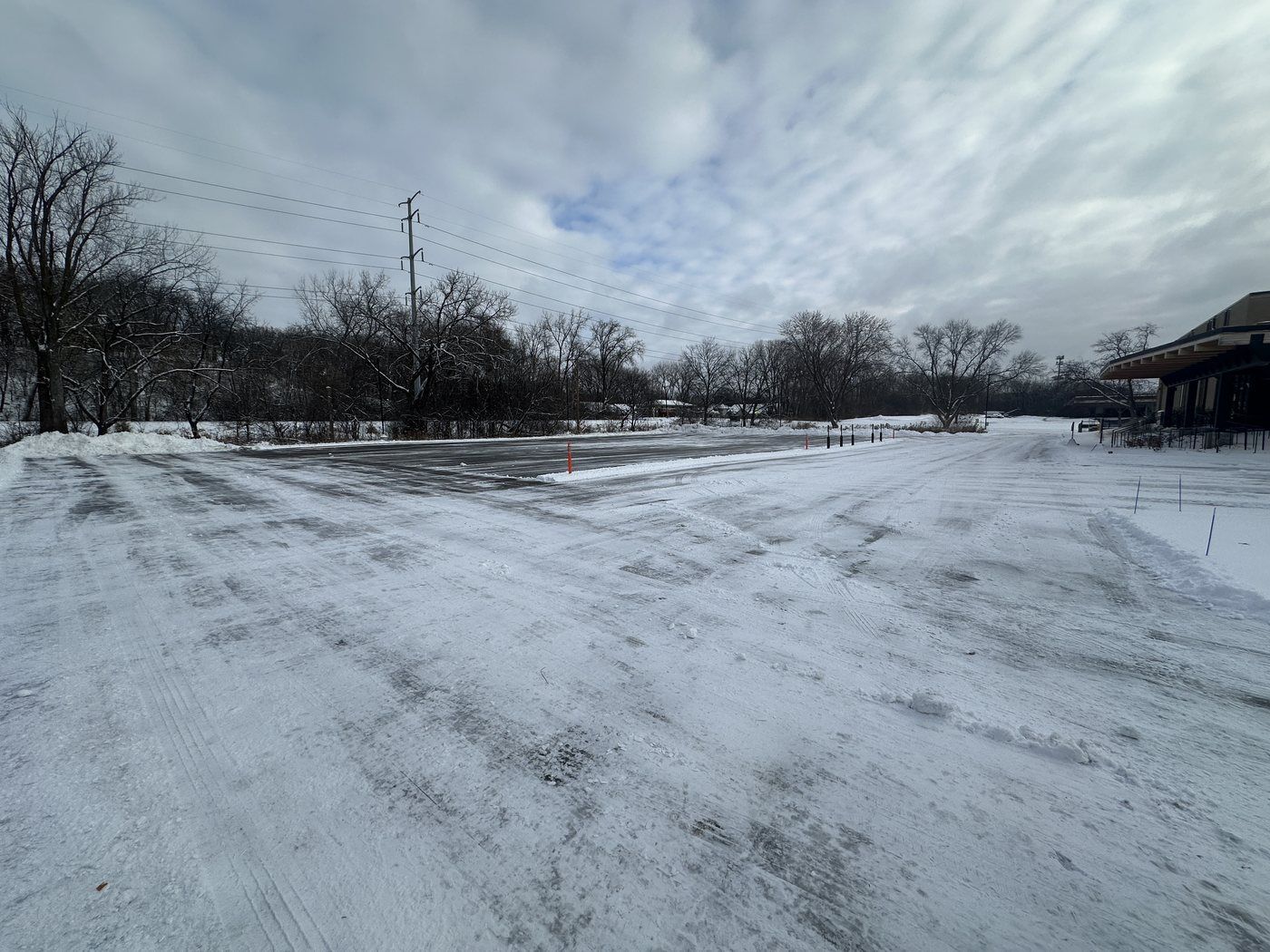 Large parking lot after plowing, drive lanes cleared from end to end