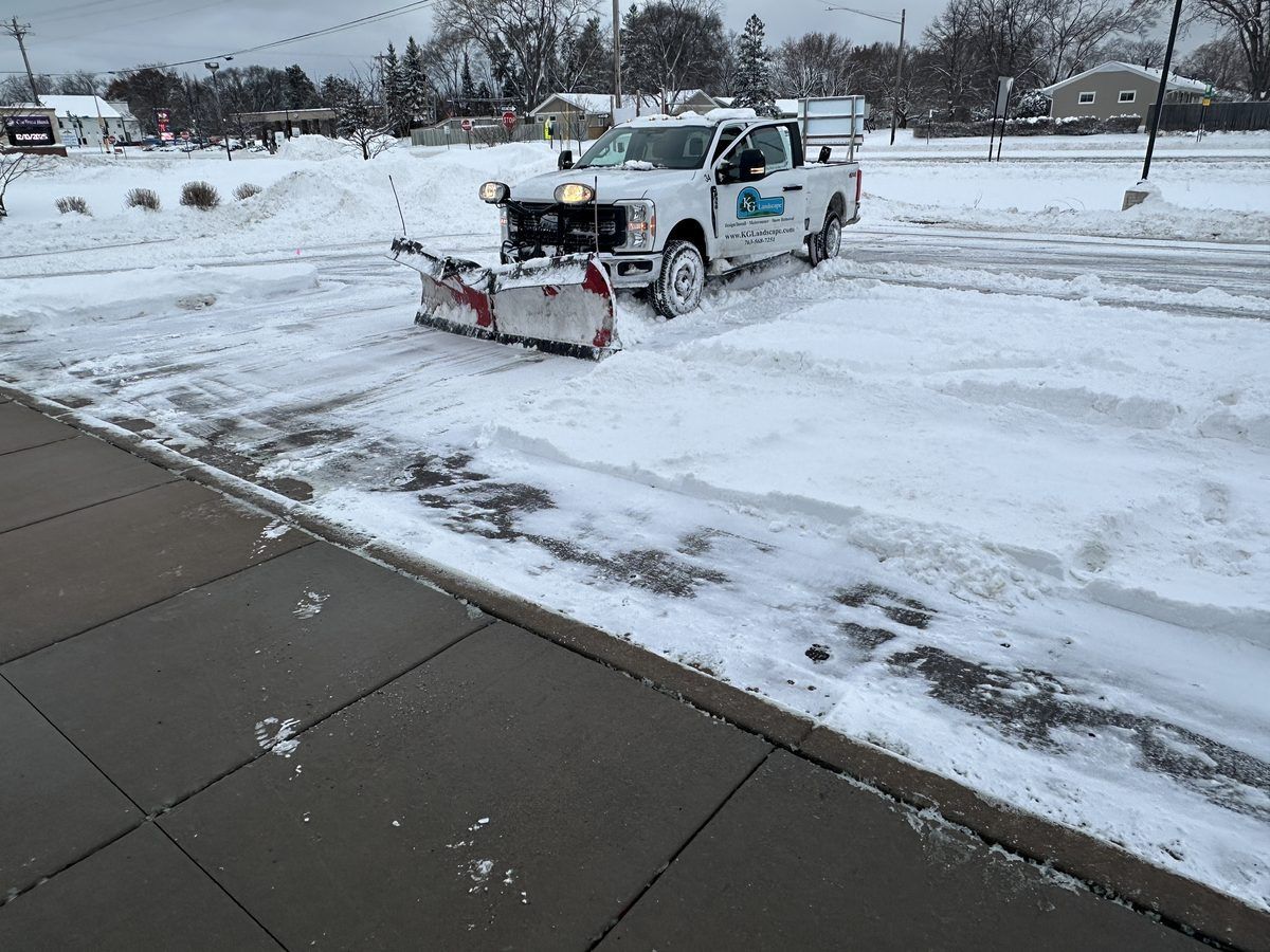 KG Landscape plow truck clearing a commercial parking lot
