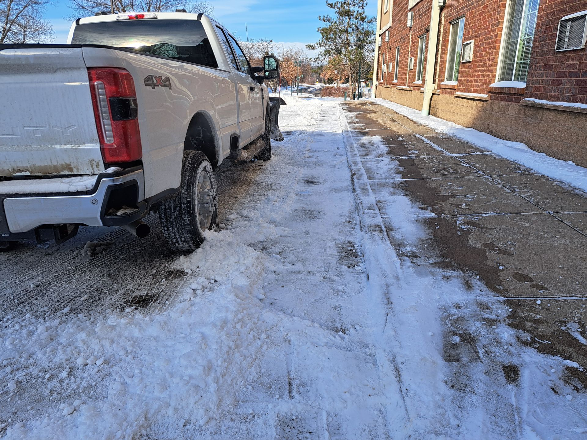 KG Landscape truck plowing curbs next to sidewalk in Minnesota