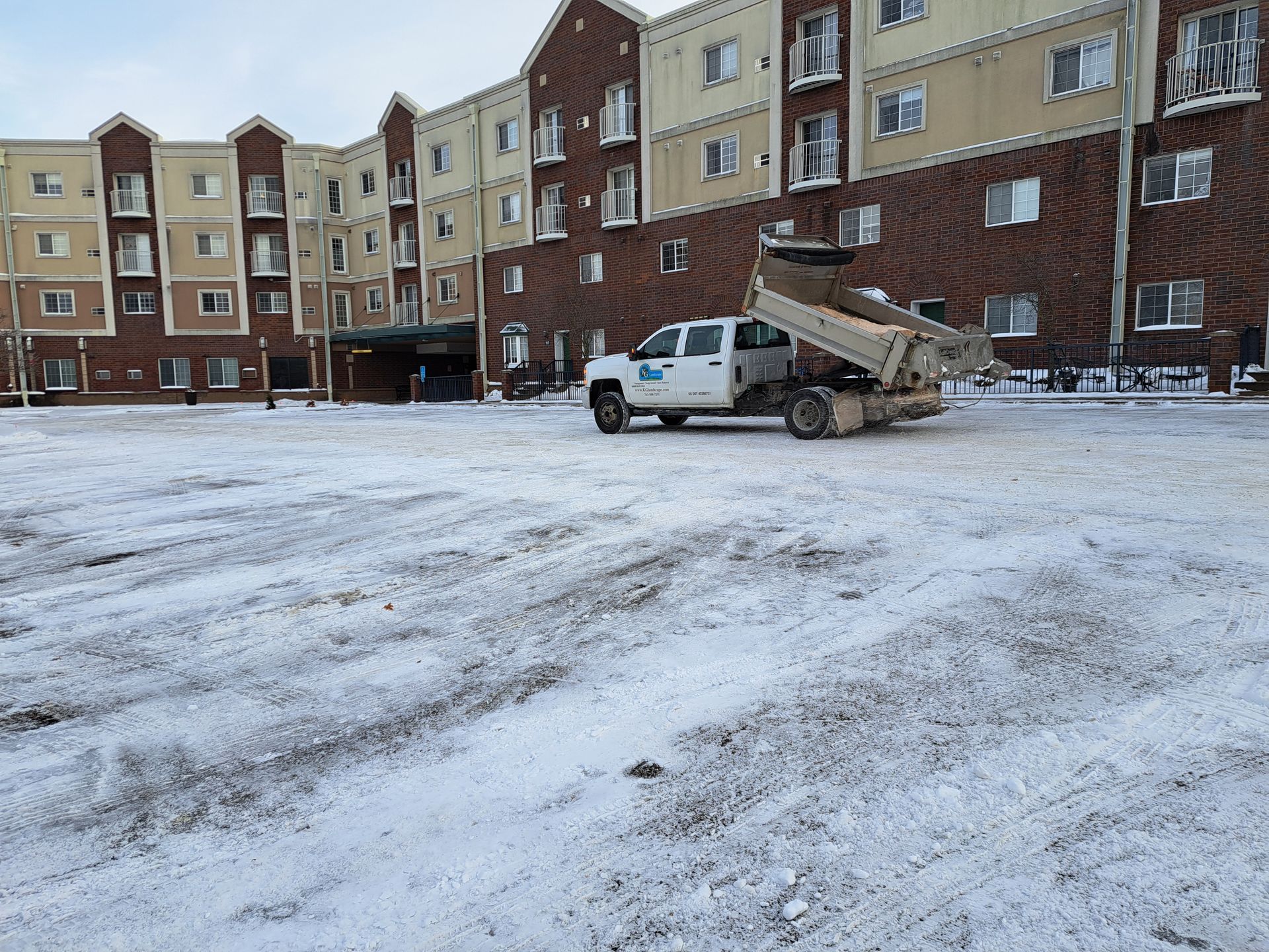 KG Landscape truck plowing and salting at a commercial building in Minnesota