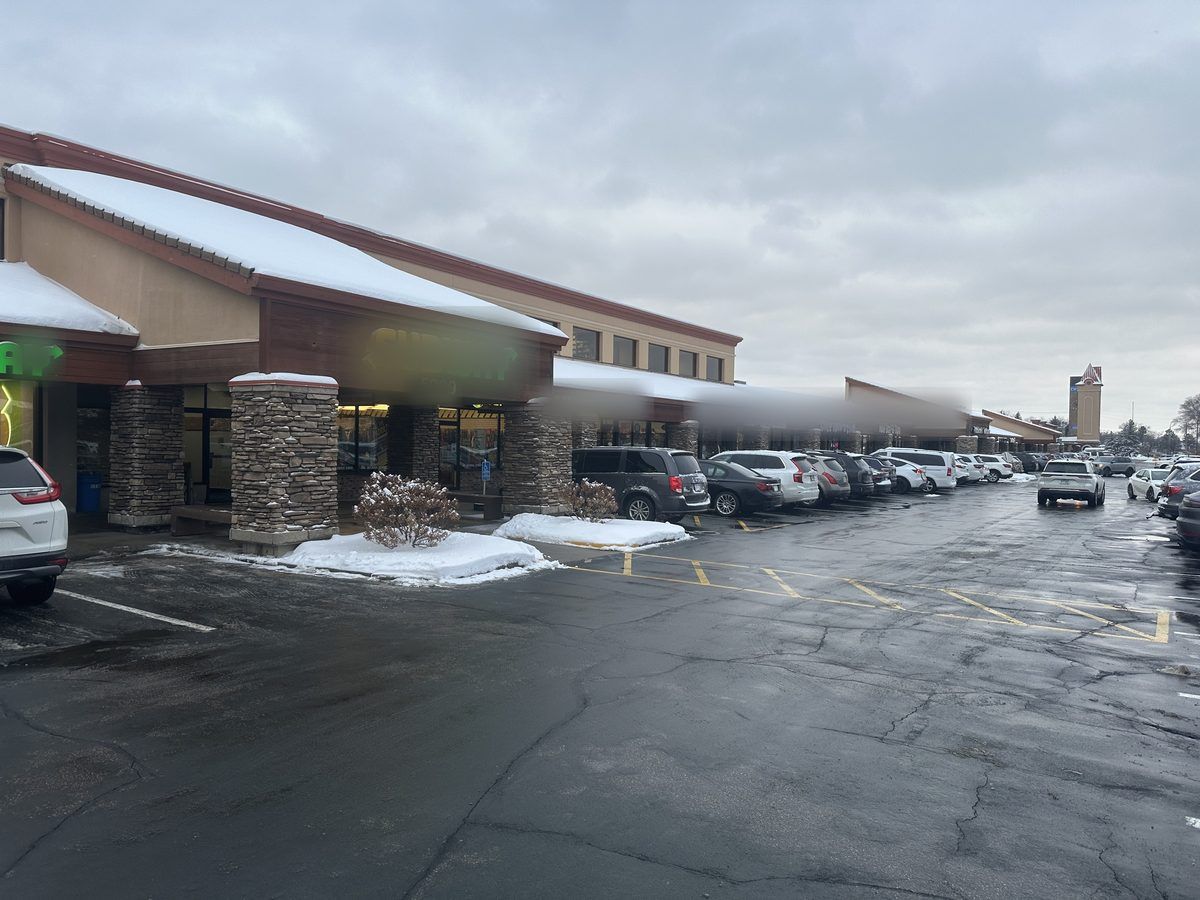 Plowed retail lot in front of a row of storefronts