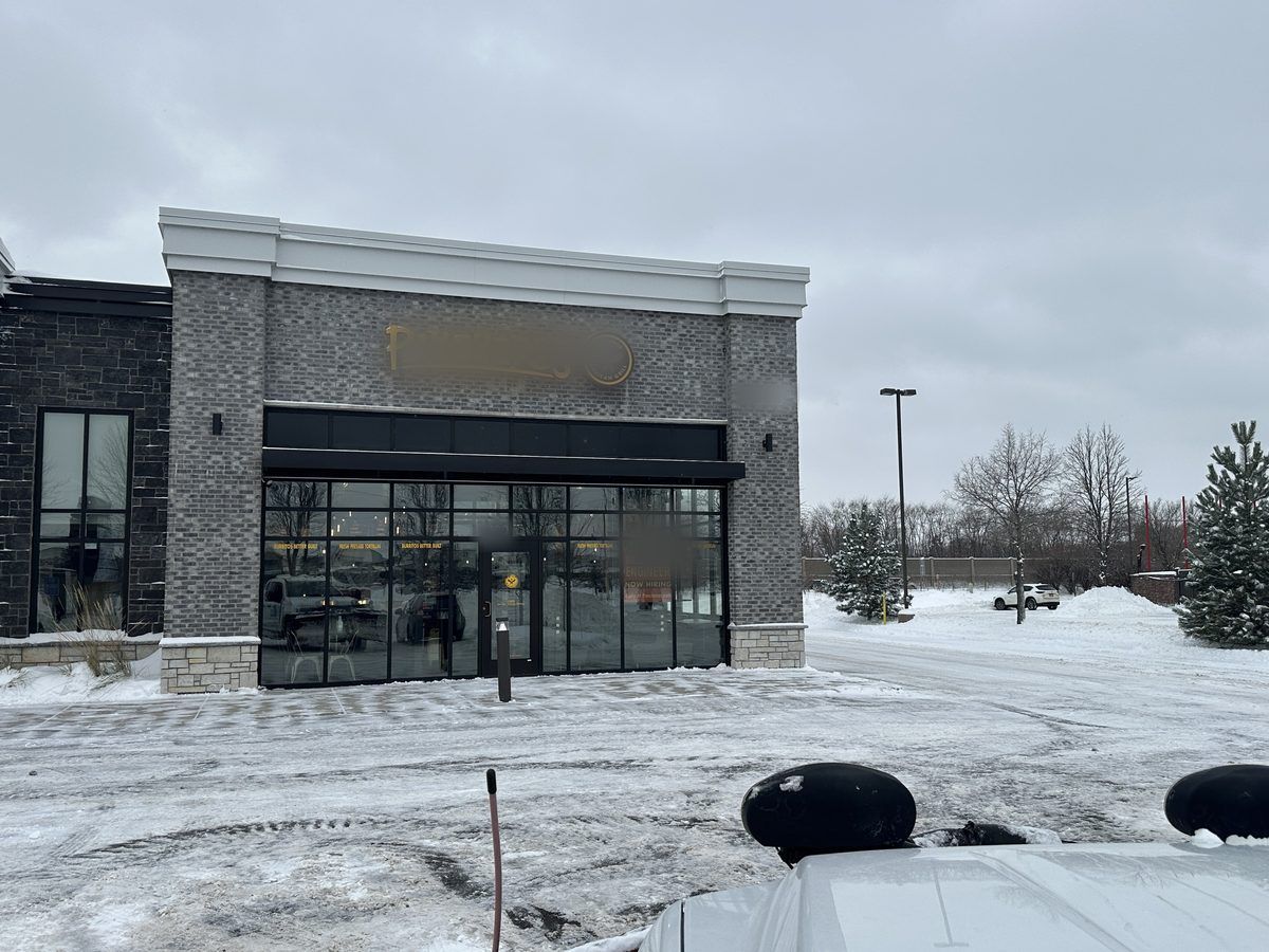 Storefront building seen from a plow truck in a snowy lot