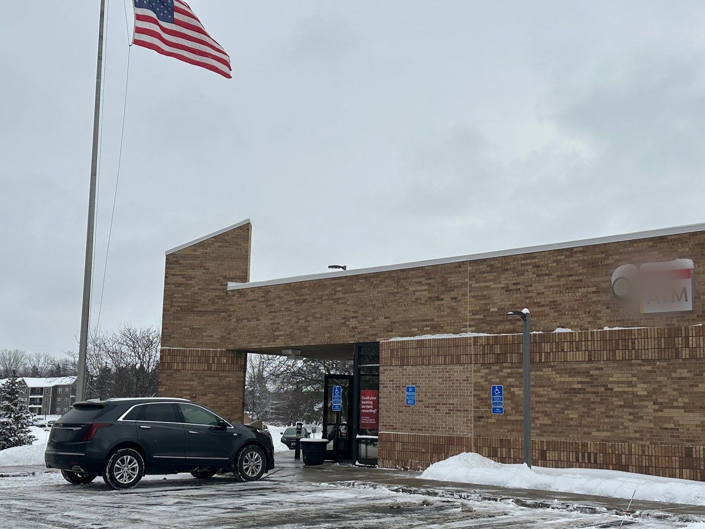 Cleared parking area at the entrance of a brick commercial building