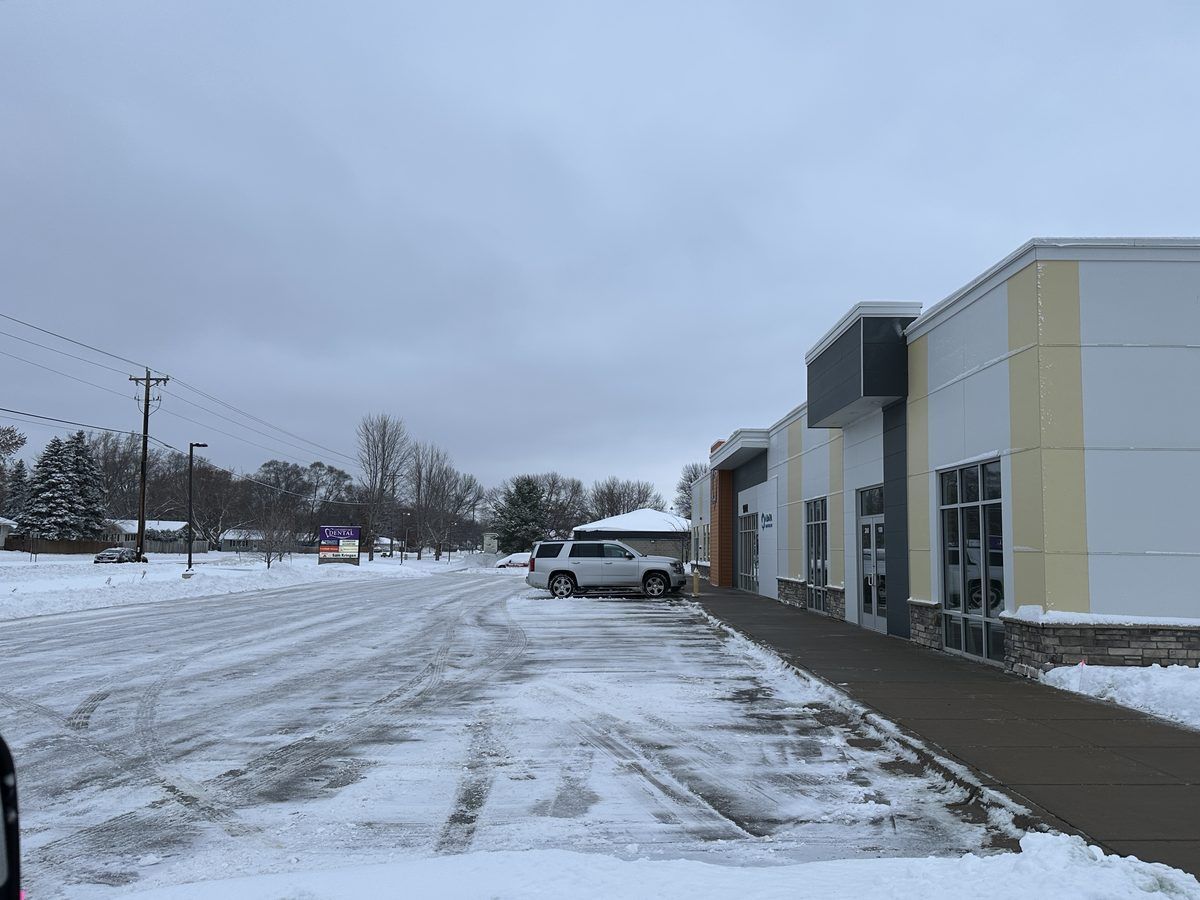 Cleared drive lane and walkway along a long commercial building