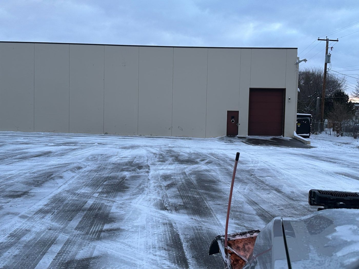 Plowed drive aisle along a tan industrial building