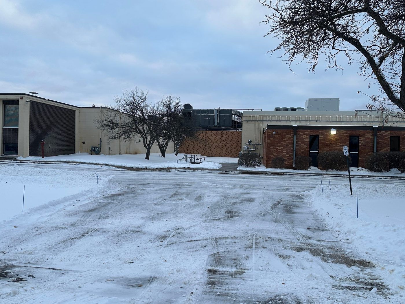 Cleared parking lot in front of a low brick and siding commercial building