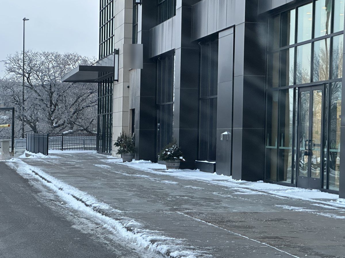 Cleared drive and walk beside a modern glass building