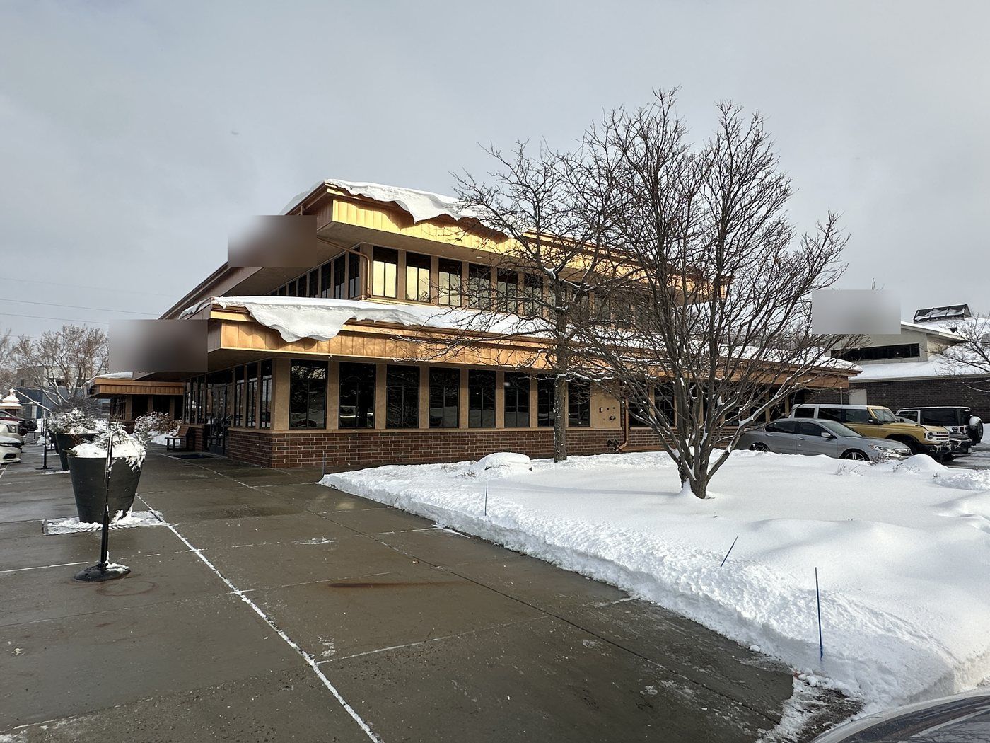 Cleared walk and plaza at the front of a two-story office building after snow