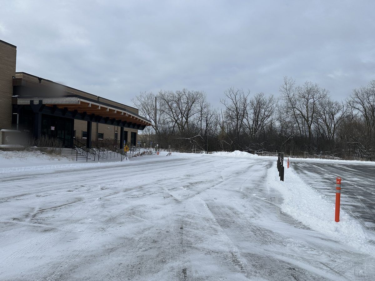 Plowed parking lot in front of a commercial building with a covered entrance