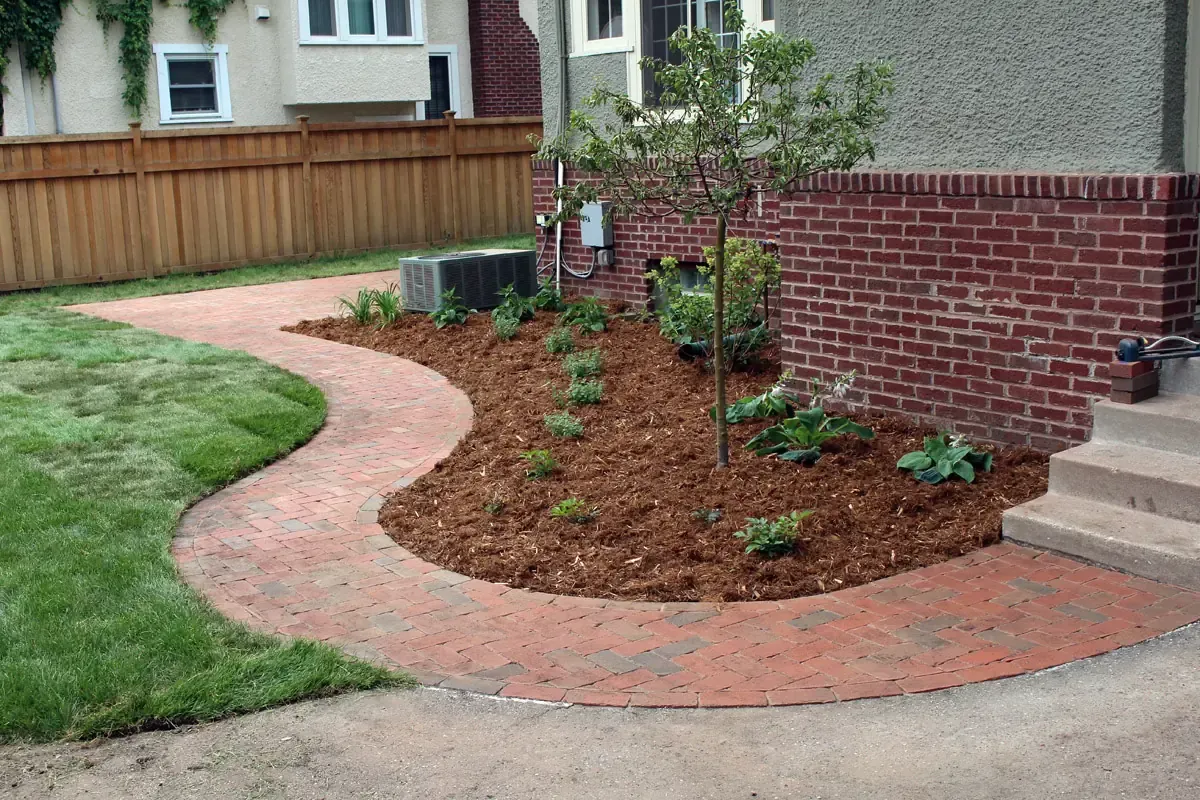 Curving red brick walkway and young Tina Crab tree in a new planting bed, 50th and Lyndale, Minneapolis