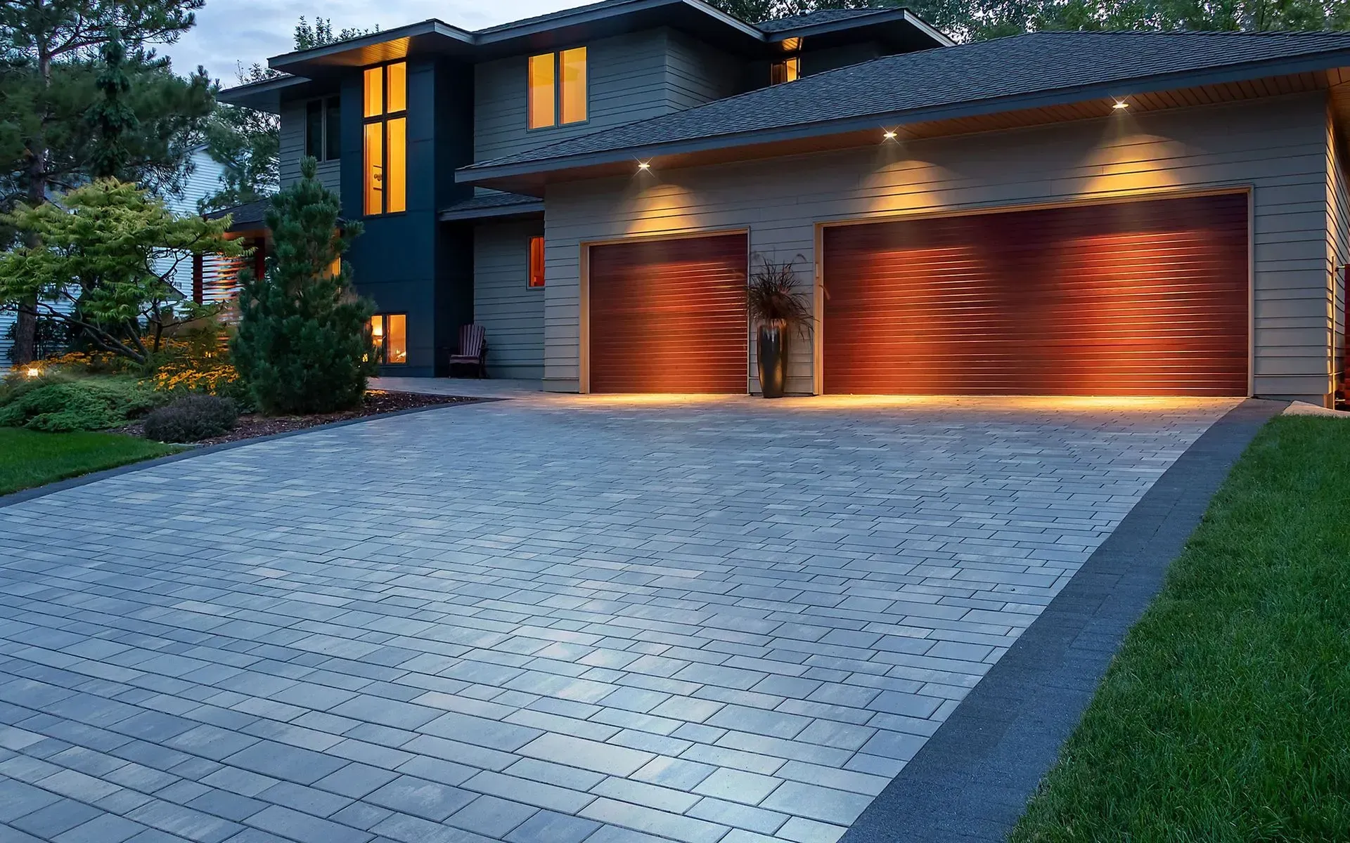 A brick driveway leading to a house with a white garage door.
