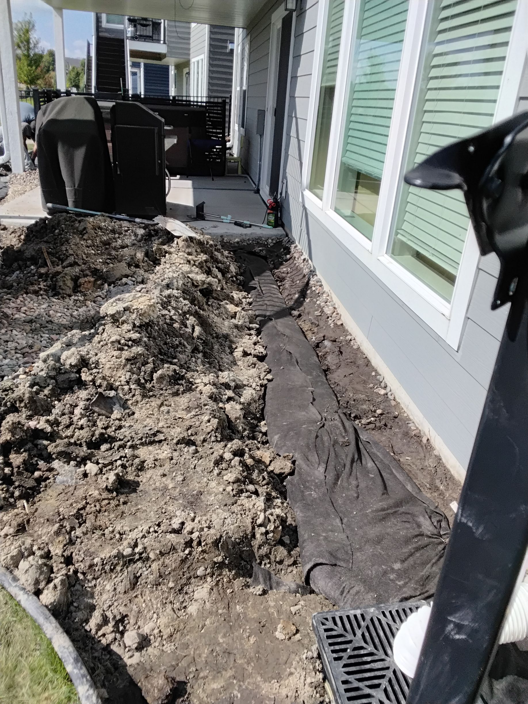French drain being installed along the back of a house in Plymouth MN