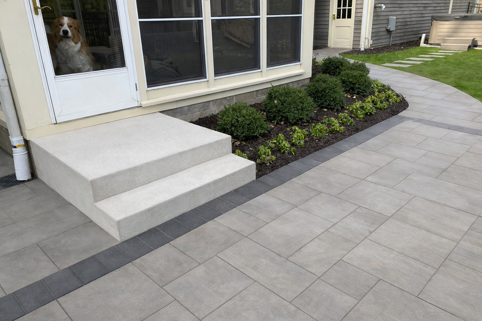 new backyard patio area with step, landing, patio, walkway, moved hot tub, etc. project by KG Landscape