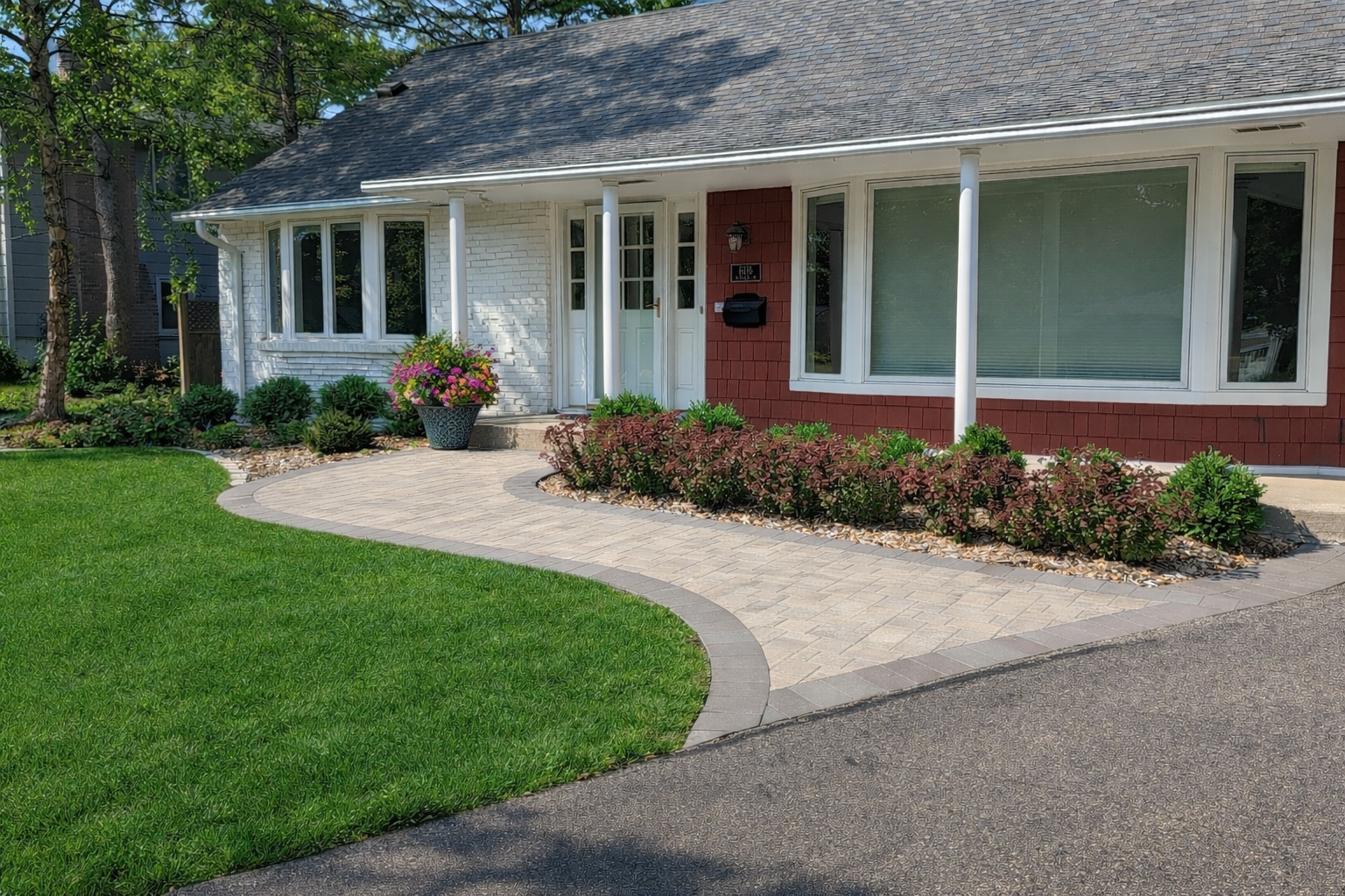 Nice house with new curved paver walkway and new landscaping with boxwoods and sedum flowers