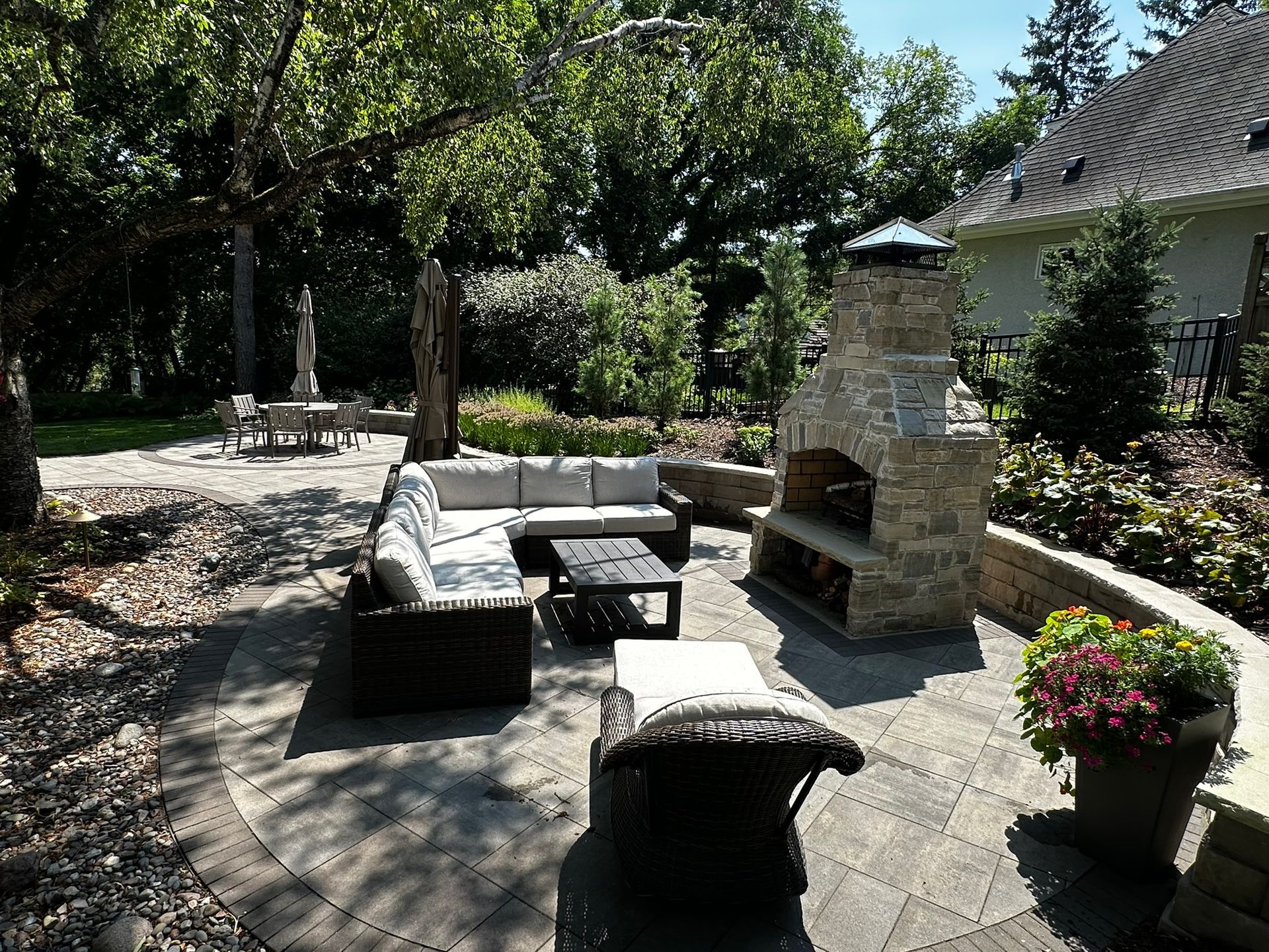 Patio with a dry creek bed drainage feature and fire feature