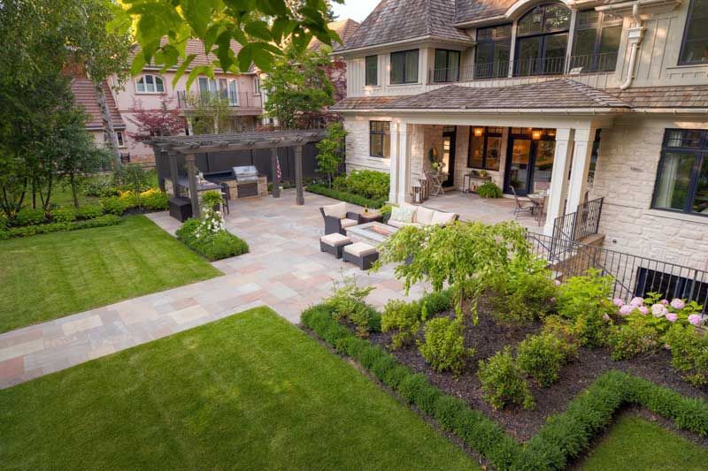 beautiful backyard stone patio with pergola outdoor living space Minneapolis MN 