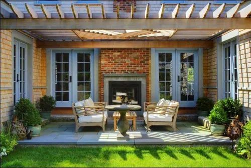 Patio with seating, fireplace, and pergola. Blue doors, brick, stone floor, grass.