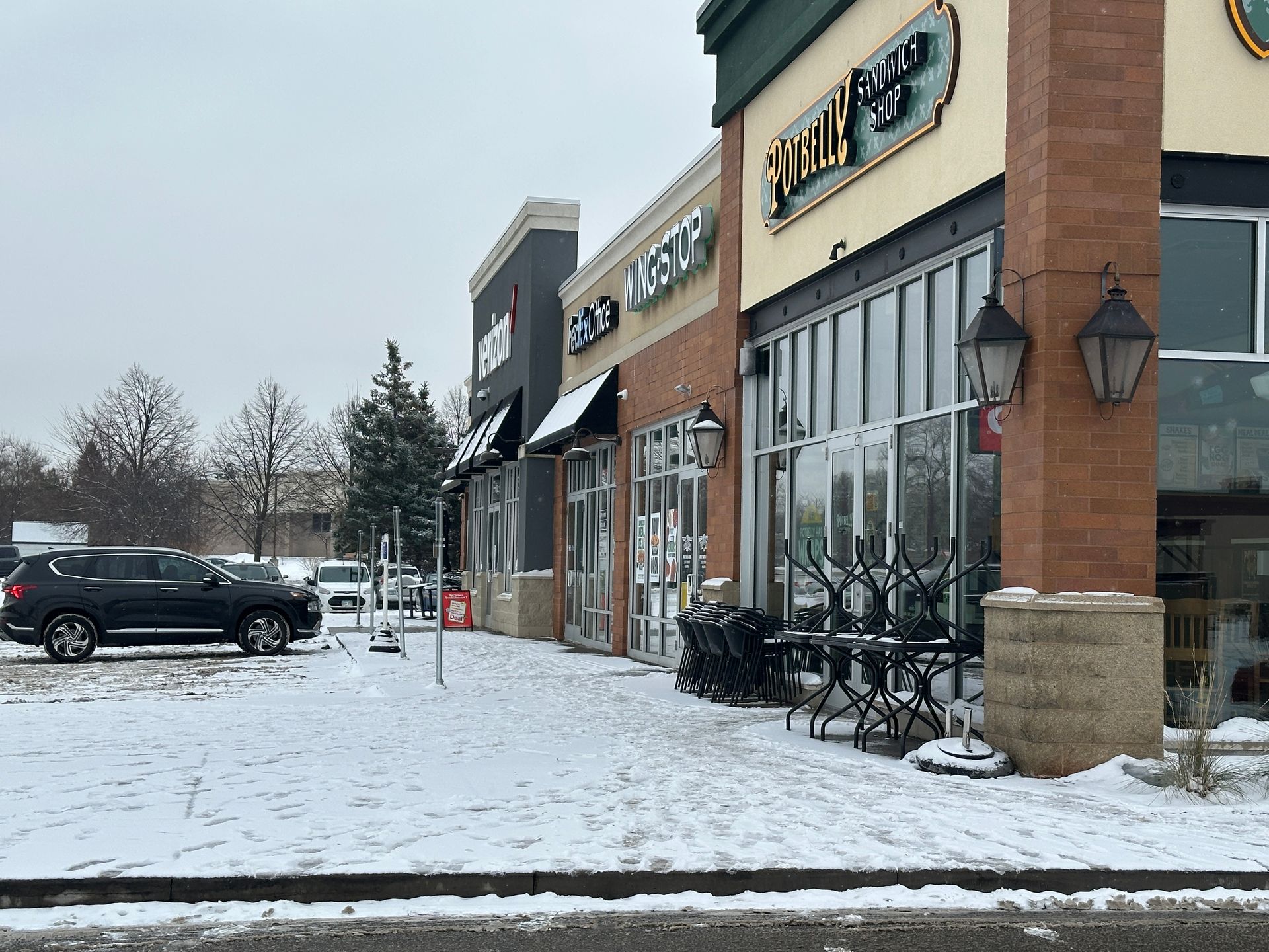Unshoveled sidewalks at a restaurant during snowfall in Minnesota