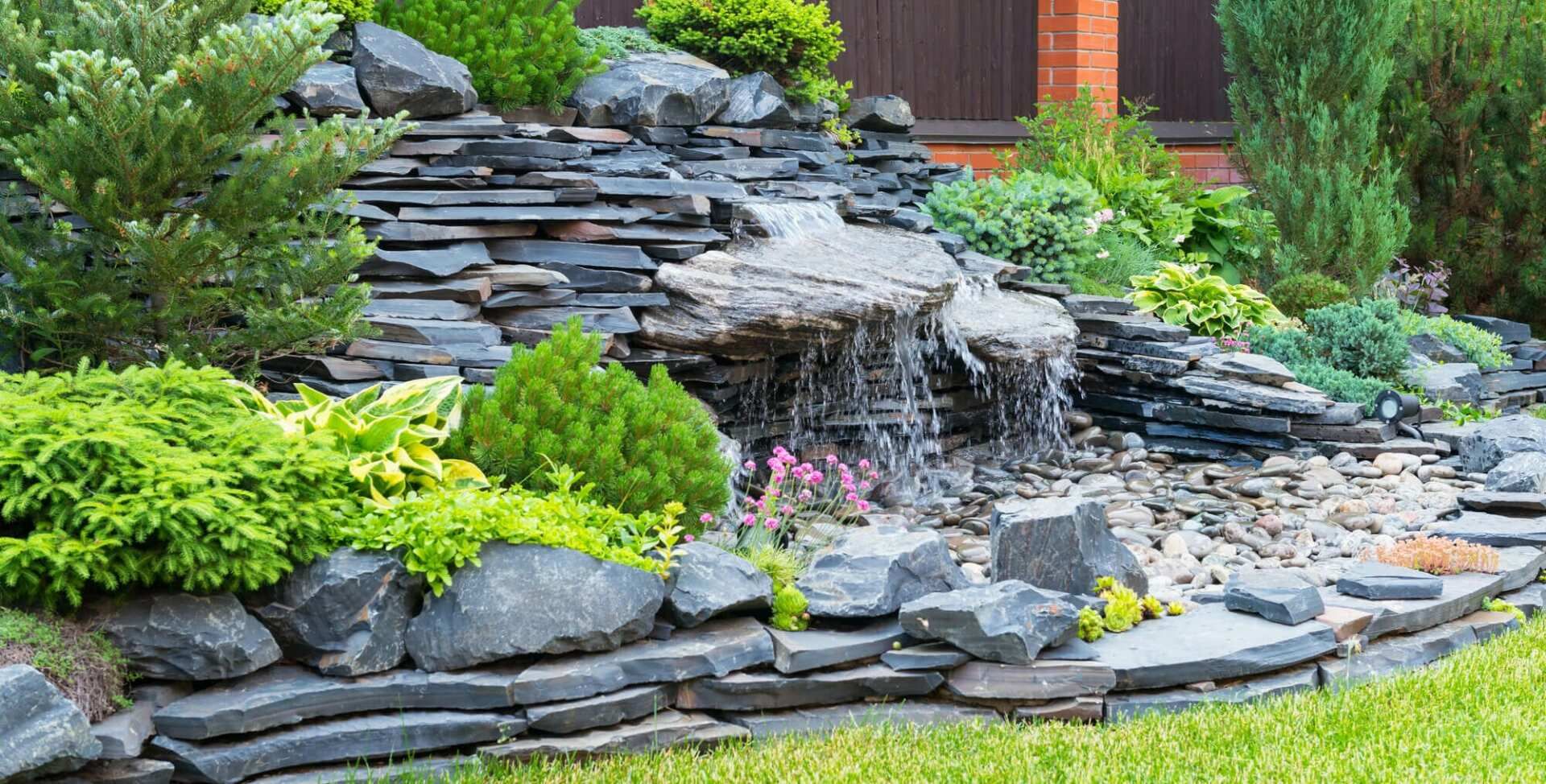 There is a waterfall in the middle of the rock garden.