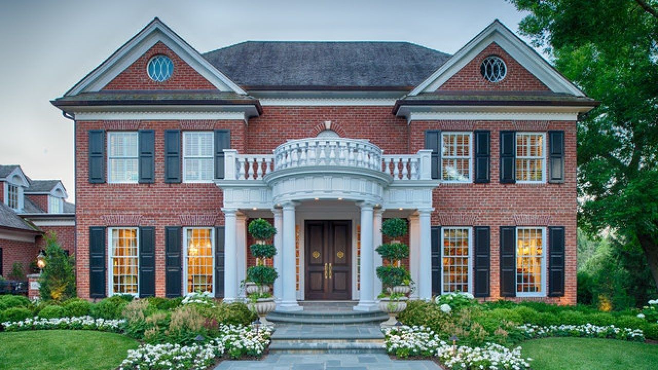 large traditional house in Minneapolis with beautiful formal landscaping with boxwood and flowers 