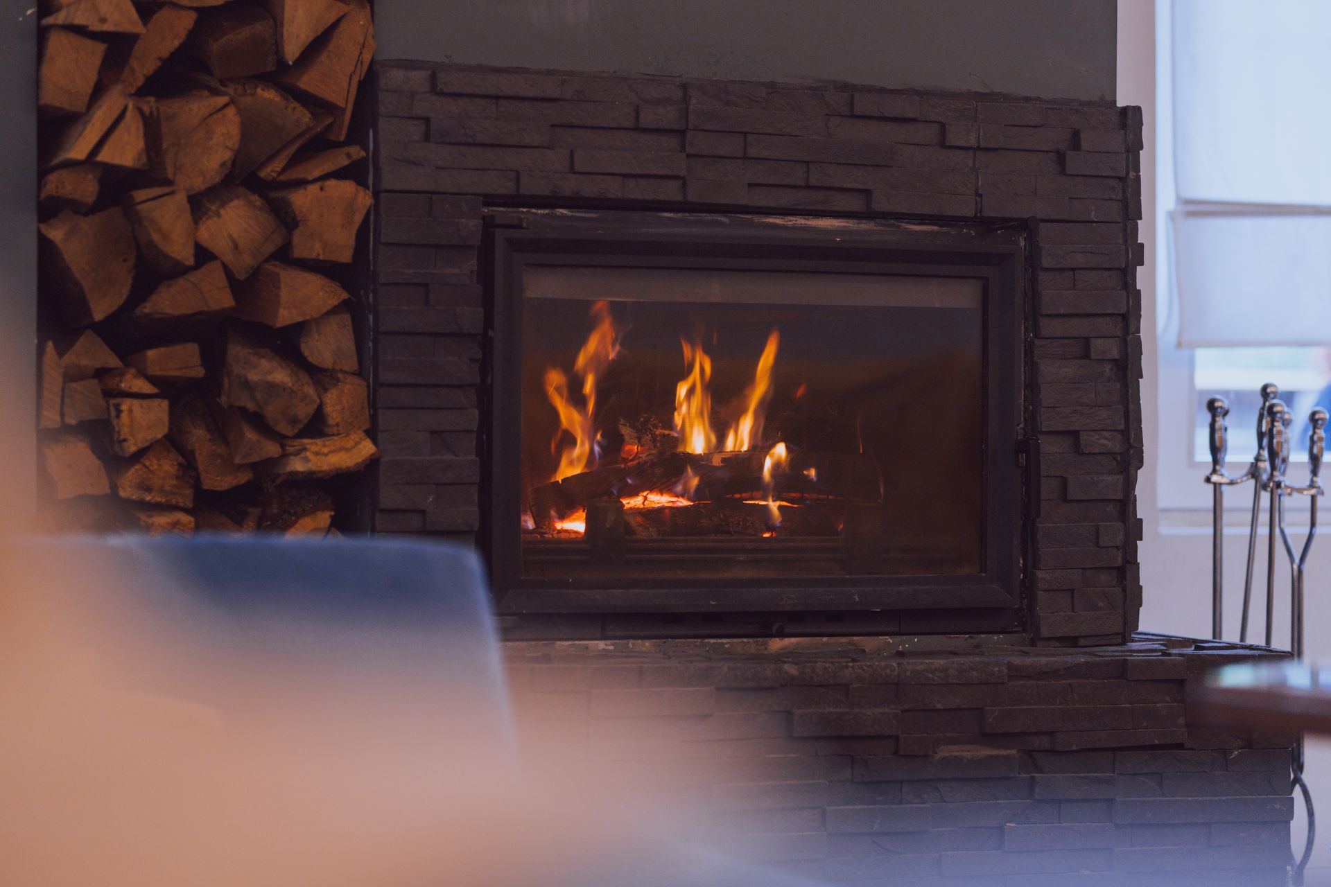 A gas fireplace with flames, blue at the base and yellow above, set in a dark frame.