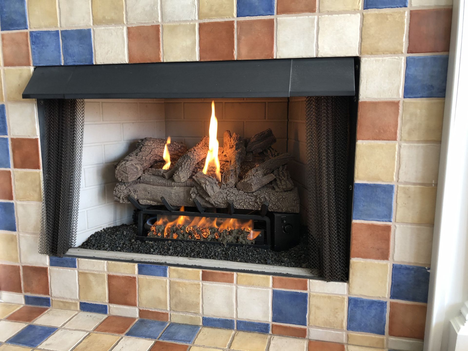 Fireplace With Flames And Ceramic Logs Set In A Tiled Surround — Falls Church, VA — Nova Gas Fireplace With Flames And Ceramic Logs Set In A Tiled Surround — Falls Church, VA — Nova Gas