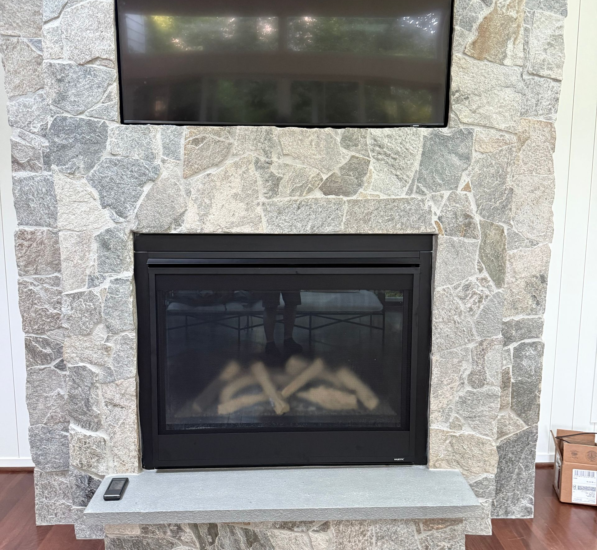 Fireplace With Stone Facade And A Black TV Above — Falls Church, VA — Nova Gas Fireplace With Stone Facade And A Black TV Above — Falls Church, VA — Nova Gas