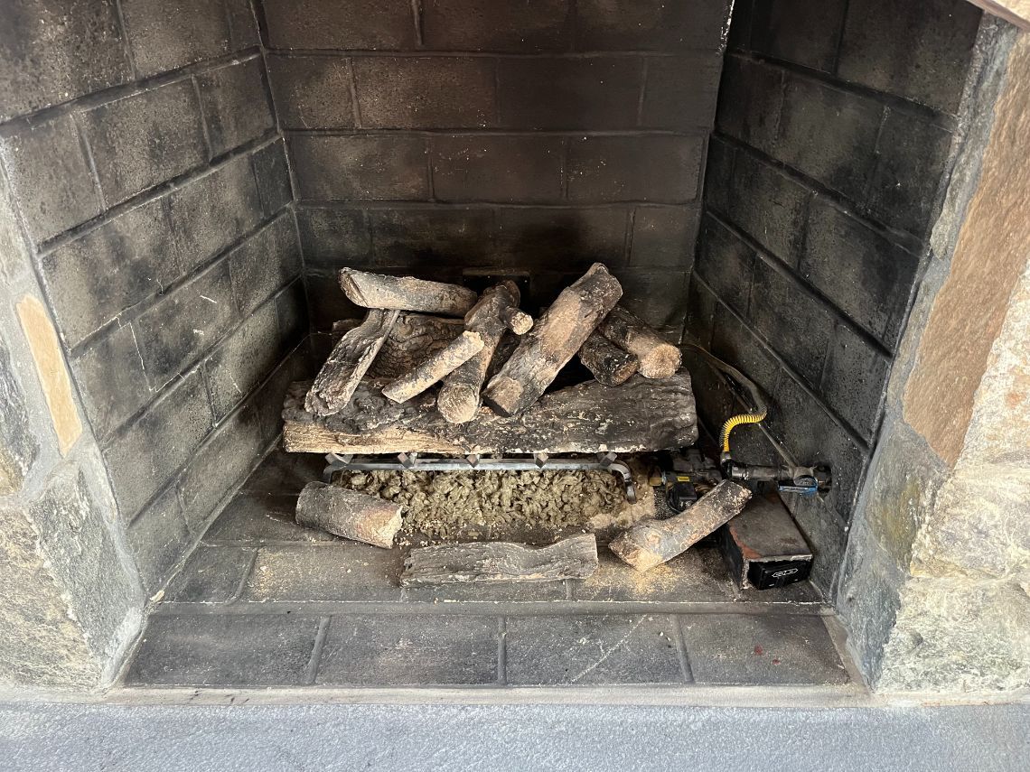 Internal view of a gas fireplace with exposed gas line.