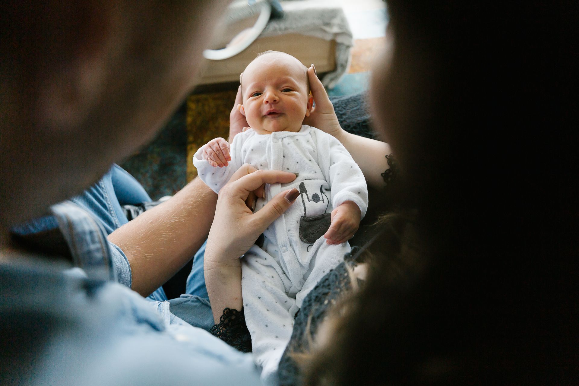 A man and woman are holding a newborn baby in their arms.