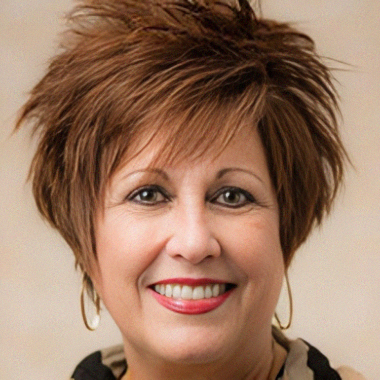 Smiling woman with short brown hair and gold hoop earrings.